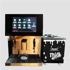 A sleek coffee machine with a digital touchscreen displaying drink options, next to a black and white milk boiler with steel lid. Modern and professional setup.